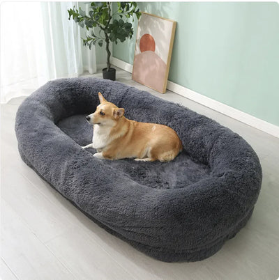 Large plush winter pet bed in gray with a dog lying comfortably inside, featuring soft, warm material and cozy design