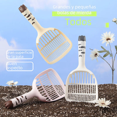 large cat litter scoop with long handle and small holes in beige pink and white colors on soil background with flowers